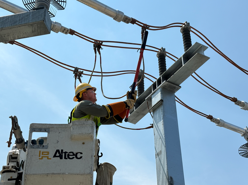 an employee in a bucket truck working on power lines